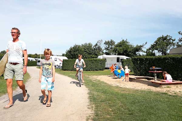 Vader en 2 zoons lopen door de camping