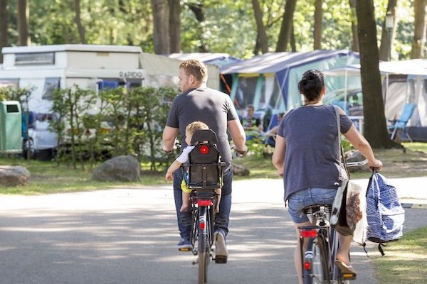 Ouders fietsen de camping op